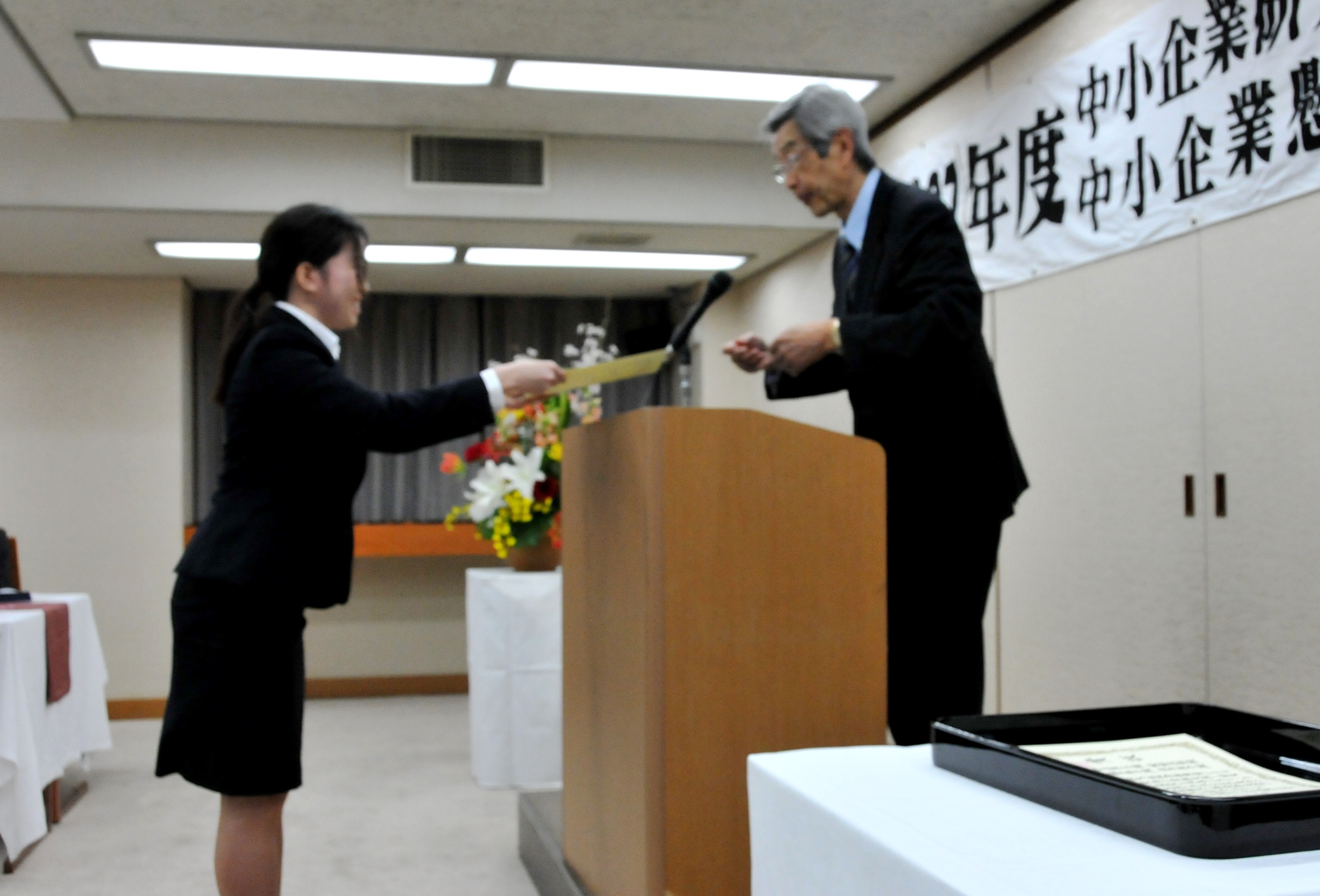 授賞式にて江崎格 商工総合研究所理事長（右）から表彰状を受け取る相川さん