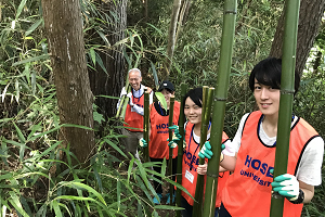 避難道を整備するため竹を運ぶ学生