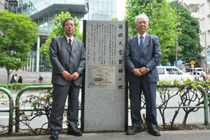記念碑の前に立つ増田総長（右）と鈴木理事