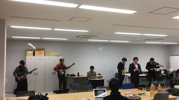 学生が手掛けた自動編曲プログラムにより、 歌、キーボード、サックス、バイオリン、ベ ースなど変則的なバンドの楽譜を作成。情 報科学部内で開催したクリスマス会で披露 した