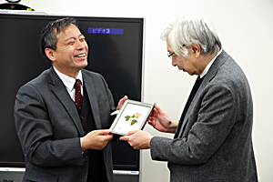 夏広志副学部長から清華大学記念品を受け取る八名副学長。 本学からの記念品も贈られた