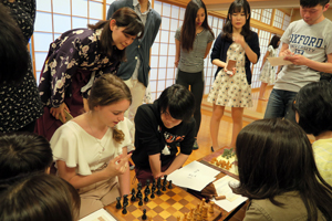 交換留学生が他の参加者にチェスを教える様子（世界の将棋に触れよう）