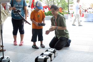 知能ロボット研究室　レスキューロボットの操作方法を子どもたちに教える様子