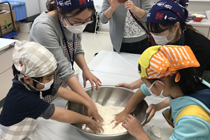 こどもたちと餃子の皮をつくる学生