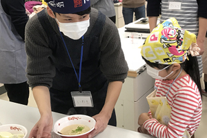 こどもたちに好みを聞きラーメンに具を載せる