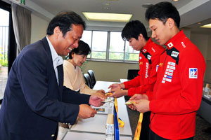 世界選手権とユニバーシアードで西藤選手・敷根選手が獲得したメダルを手に取る田中総長と近藤常務理事