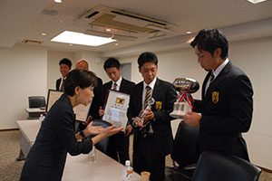 日本一で獲得したカップ、盾、賞状を一つずつ確認される田中総長