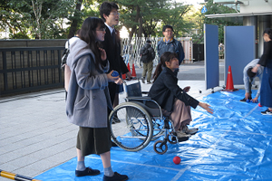 車いすにのってボールを投げる学生