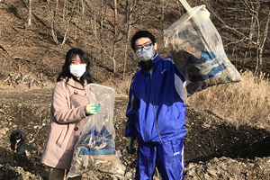 集めたゴミを掲げる学生