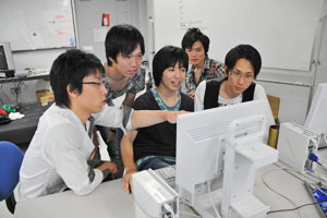 PC前で調査データについて話し合う研究室の学生たち