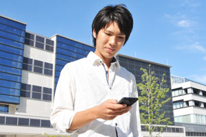 受賞研究「Android 端末による位置情報の推定」で、センサーによるデータ収集のため小金井キャンパスを歩く太田さん。市街地でも、同じ場所を何度も歩き検証した